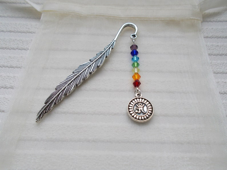 May include: Silver feather bookmark with a rainbow of crystal beads and a silver charm with an Om symbol.