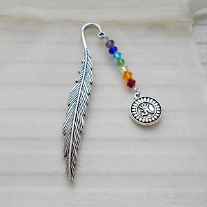 May include: A silver feather bookmark with a rainbow colored beaded chain and a silver charm with an Om symbol.