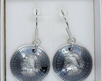 May include: Silver coin earrings featuring a profile of a person wearing a feathered headdress. The coins are inscribed with "5 CENT. TEN. FINE SILVER" and "ONCE. FIVE SILVER".