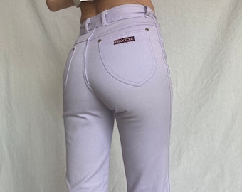 May include: A pair of lavender-colored high-waisted jeans with a