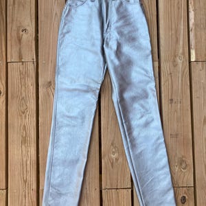 Peut inclure: Pantalon taille haute bleu clair avec un aspect m&eacute;tallique. Le pantalon a une conception classique &agrave; cinq poches, une fermeture &agrave; bouton et &agrave; glissi&egrave;re, et une jambe droite. Le mat&eacute;riau est lisse, peut-&ecirc;tre du similicuir.