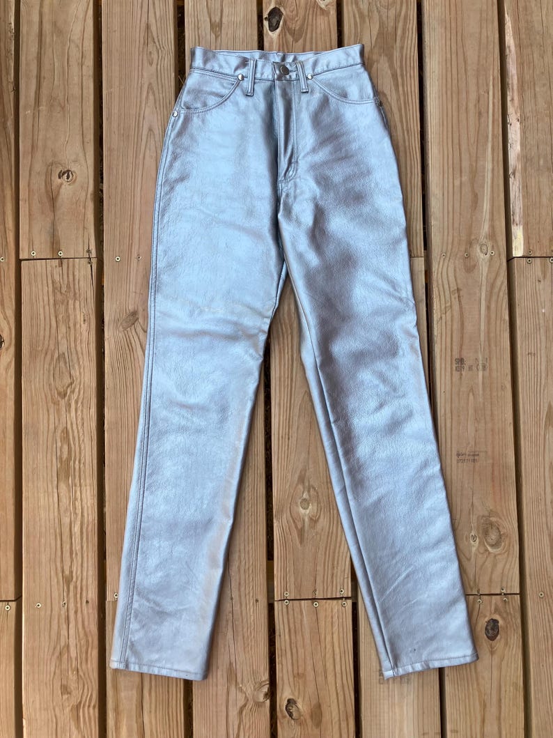 Peut inclure: Pantalon taille haute bleu clair avec un aspect m&eacute;tallique. Le pantalon a une conception classique &agrave; cinq poches, une fermeture &agrave; bouton et &agrave; glissi&egrave;re, et une jambe droite. Le mat&eacute;riau est lisse, peut-&ecirc;tre du similicuir.