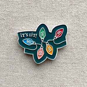 It&#39;s Lit Christmas Lights enamel pin – Spread the holiday cheer with our colorful Christmas Bulb enamel pin. Great stocking stuffer gift!