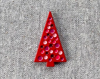 May include: A red Christmas tree ornament with pink and white polka dots.