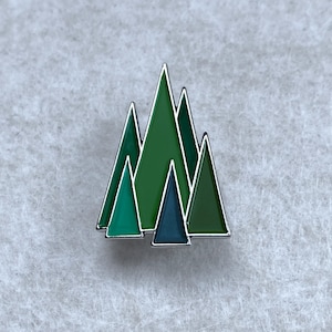 Tree Forest Winter enamel pin – Sleek, stylish group of Christmas trees in a variety of greens. Great stocking stuffer. Secret Santa gift.