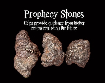 May include: Three dark, textured Prophecy Stones are displayed against a black background. The stones have a rough, uneven surface and varying shapes. Text above reads "Prophecy Stones" and "Helps provide guidance from higher realms regarding the future."