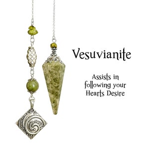 Peut inclure: Deux pendules en cristal de vésuvianite avec chaînes et détails argentés. L'un est en forme de cône facetté, l'autre avec un charm carré et des perles vertes. Le texte indique "Vesuvianite" et "Assists in following your Hearts Desire."