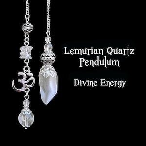 May include: Two Lemurian Quartz pendulums hang against a black background. One features an Om symbol and clear quartz accents. The other has a silver-toned decorative top. Text reads "Lemurian Quartz Pendulum" and "Divine Energy."