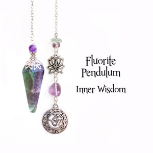 May include: Two fluorite pendulums with silver chains. One has a faceted, purple and green crystal with a decorative silver cap. The other has a lotus charm, amethyst and a silver Om symbol. Text reads "Fluorite Pendulum Inner Wisdom."