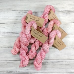 May include: Five skeins of pink yarn with brown labels that read "The Craft That" and "Treasure Dust" with the words "Atmosphere" on some of the labels.