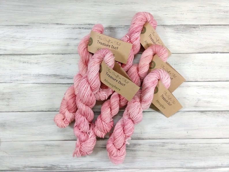 May include: Five skeins of pink yarn with brown labels that read "The Craft That" and "Treasure Dust" with the words "Atmosphere" on some of the labels.