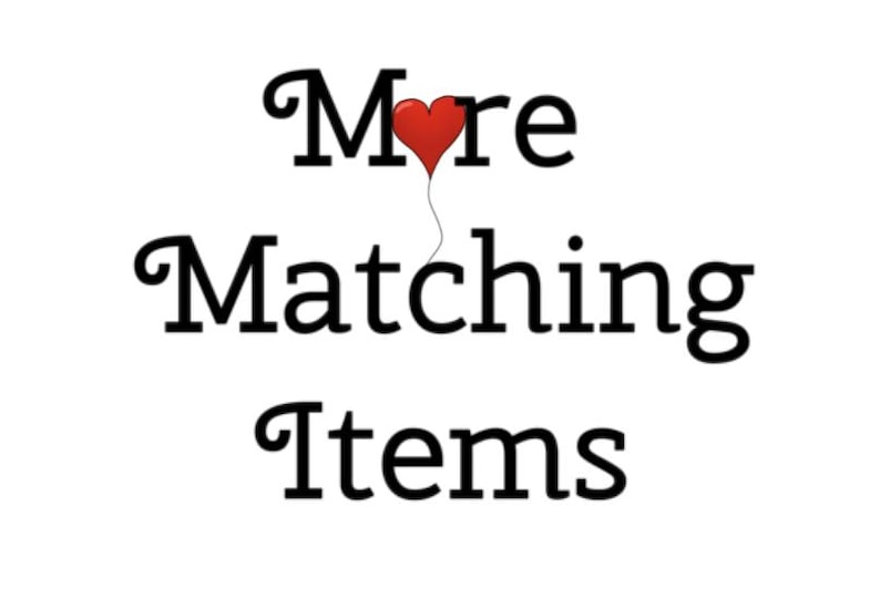 May include: The text "More Matching Items" is written in a black serif font. A small, red, heart-shaped balloon is attached to a thin black string that extends downward from the heart, replacing the letter "o" in the word "More".