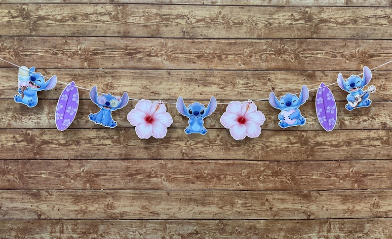 Op de afbeelding: Een slinger met het personage Stitch, surfplanken en hibiscusbloemen. De blauwe Stitch-figuren staan in verschillende poses, sommigen houden ijs of een ukelele vast. De surfplanken zijn paars met witte bloempatronen.