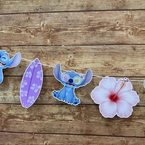 Op de afbeelding: Een slinger met uitgesneden decoraties met het personage Stitch, een paars surfplank en een roze hibiscusbloem. De Stitch-personages zijn blauw en houden ijsjes vast of dragen een zonnebril.