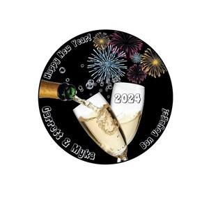Puede incluir: Un dise&ntilde;o circular en blanco y negro con una botella de champ&aacute;n que se vierte en dos copas de champ&aacute;n. Las copas se levantan en un brindis. El texto "Happy New Year!" est&aacute; escrito en un c&iacute;rculo alrededor de la parte superior del dise&ntilde;o. El texto "Garrett & Myka" est&aacute; escrito en un c&iacute;rculo alrededor de la parte inferior izquierda del dise&ntilde;o. El texto "Bon Voyage!" est&aacute; escrito en un c&iacute;rculo alrededor de la parte inferior derecha del dise&ntilde;o. El a&ntilde;o "2024" est&aacute; escrito en blanco en la parte frontal de las copas. El fondo es negro con fuegos artificiales coloridos.