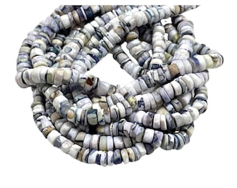 Può includere: Una collana di perline di conchiglia bianche e blu. Le perline sono di forma irregolare e hanno un aspetto naturale e organico.