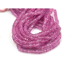 May include: A strand of pink gemstone beads. The beads are faceted and have a square shape. The beads are strung on a clear thread.