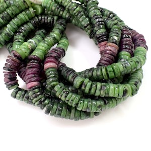 May include: Strands of gemstone beads in shades of green and deep red. The beads are disc-shaped and appear to be made of natural stone. The green beads have dark speckles, while the red beads have a rich, saturated color. The beads are strung together.
