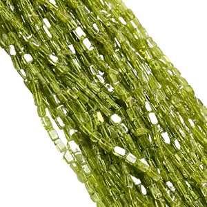 May include: A strand of green peridot beads, each bead is faceted and has a rectangular shape.