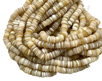 Può includere: Una collana di perline di conchiglia di colore bianco e crema. Le perline sono piatte e rotonde, e sono infilate su un filo trasparente.