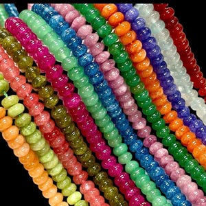 Peut inclure: Une collection de perles rondes en verre de différentes couleurs avec une texture mouchetée. Les perles sont disposées en rangées, chaque rangée présentant une couleur différente. Les couleurs comprennent le vert, le bleu, le rose, l'orange et le rouge.