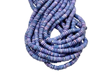May include: A bundle of round, flat beads in shades of blue and purple. The beads are stacked together, creating a layered effect. The beads appear to be made of a smooth material, and the color variation gives them a natural look. The background is plain white.