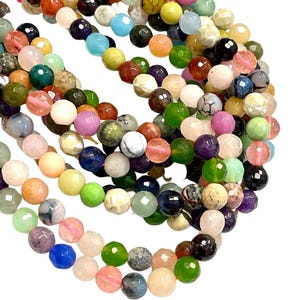 May include: A collection of colorful gemstone beads, featuring various shades of green, pink, blue, and brown. The beads are round and have a faceted finish, creating a shimmering effect.