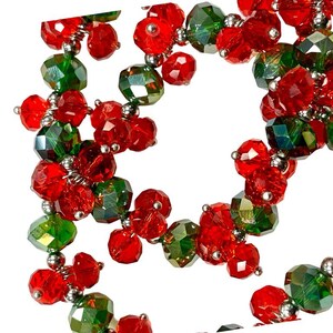 May include: A strand of red and green glass beads, strung together with silver wire. The beads are faceted and have a sparkly finish.