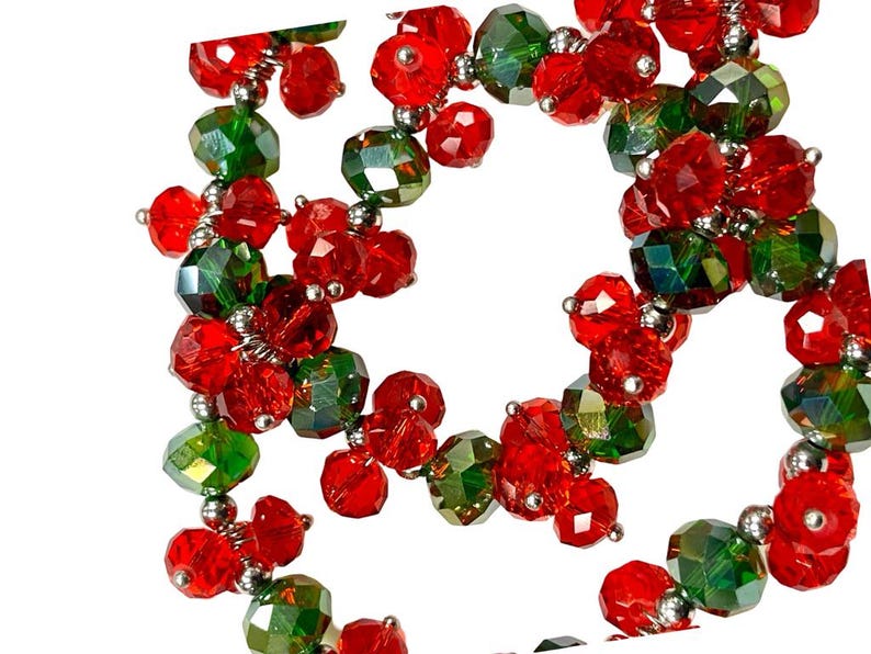 May include: A strand of red and green glass beads, strung together with silver wire. The beads are faceted and have a sparkly finish.