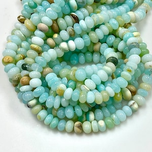May include: A strand of light blue, green, and white opal beads. The beads are small and round, and they are strung on a clear thread.