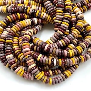 May include: Strands of colorful, flat, round beads in shades of yellow, brown, pink, and gray. The beads are strung together, creating a textured and layered appearance. The beads are likely for jewelry making or crafting.