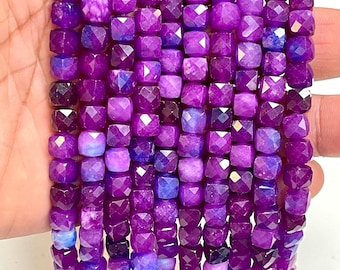 Peut inclure: Plusieurs rangées de perles violettes facettées de forme carrée. Les perles présentent une gamme de teintes violettes, du violet foncé aux nuances plus claires. Idéal pour la création de bijoux.