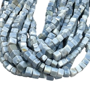 Puede incluir: Hilo de cuentas cúbicas azul claro. Las cuentas tienen un aspecto veteado con variaciones de azul claro y gris. Las cuentas están ensartadas, formando un hilo flexible. Ideal para la fabricación de joyas o proyectos de artesanía.