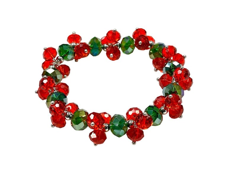 May include: A red and green beaded bracelet with a silver clasp. The beads are faceted and have a sparkly finish.