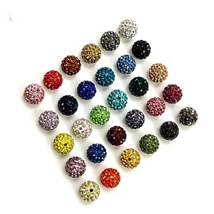 Peut inclure: Assortiment de 24 perles en strass color&eacute;es. Chaque perle mesure environ 2 cm de diam&egrave;tre et pr&eacute;sente une finition brillante et cristalline.