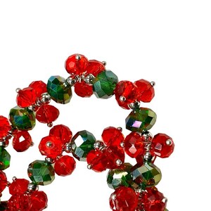 May include: A close-up of a red and green beaded garland. The beads are made of glass and have a shiny finish. The garland is strung on a silver wire.