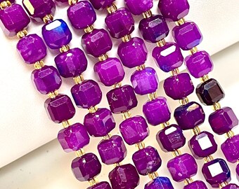 Peut inclure: Gros plan sur plusieurs brins de perles de pierres précieuses violettes profondes et facettées. Les perles sont de forme carrée avec des entretoises dorées. Les pierres précieuses ont une surface polie et réfléchissante.