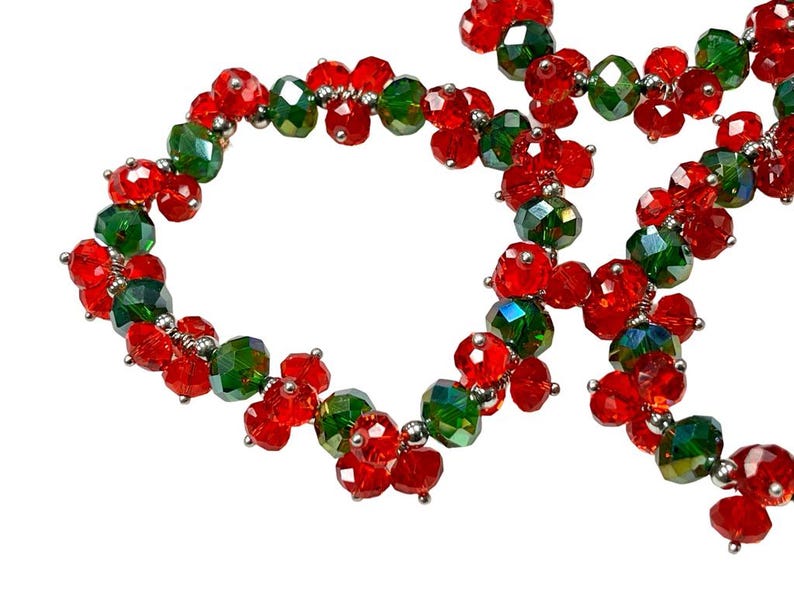 May include: A red and green beaded necklace with alternating crystal beads. The necklace is made of small, faceted beads that are strung together on a silver wire.