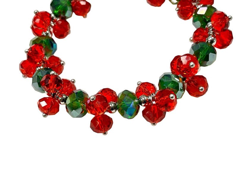 May include: A red and green beaded bracelet with a silver wire connecting the beads.