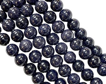 May include: A strand of dark blue round beads with a speckled texture. The beads are made of natural stone and are perfect for jewelry making.