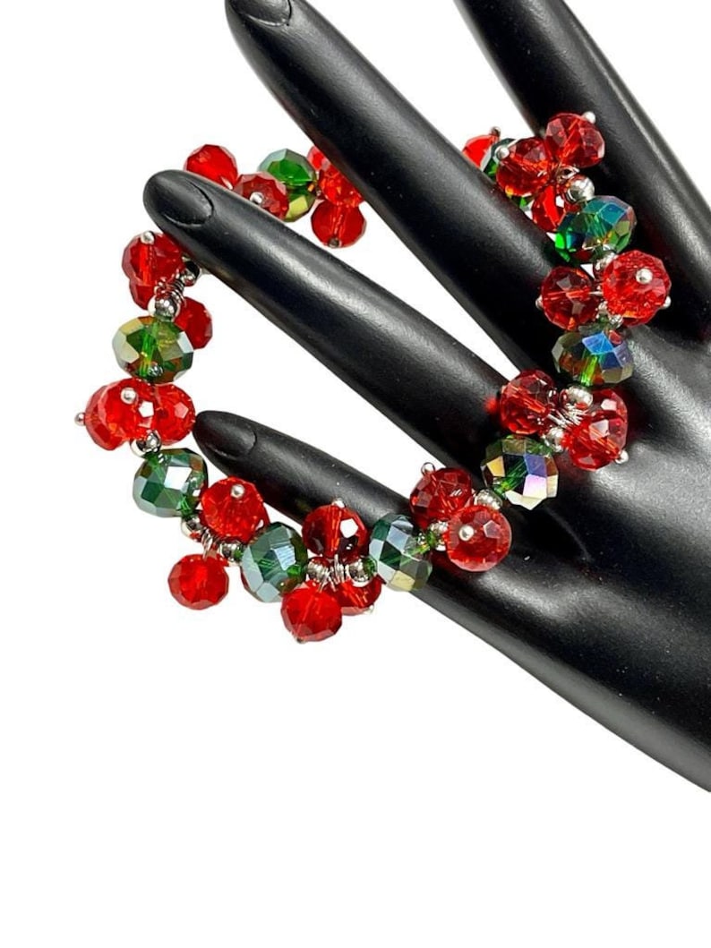 May include: Red and green crystal beaded bracelet. The bracelet is made with faceted red and green crystals, and silver wire.