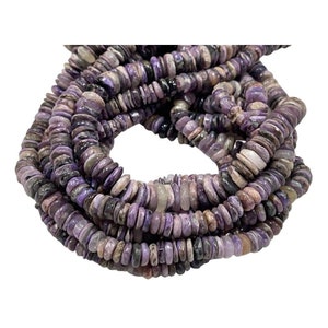 Puede incluir: Una hebra de cuentas de piedras preciosas de color púrpura y gris, cada cuenta es un disco plano y redondo con una forma ligeramente irregular.