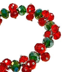 May include: A red and green beaded bracelet with a festive holiday theme.
