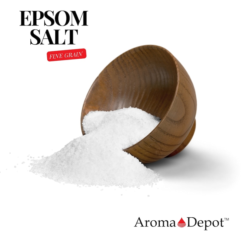 May include: A wooden bowl overflowing with fine grain Epsom salt, spilling onto a white surface. The bowl is tipped over, with the salt cascading out. The text "EPSOM SALT FINE GRAIN" is visible in the top left corner of the image. The text "Aroma Depot" is visible in the bottom right corner of the image.
