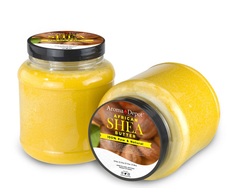 May include: Two glass jars filled with yellow shea butter. The jars have black lids and labels that say "Aroma Depot African Shea Butter 100% Raw & Natural".