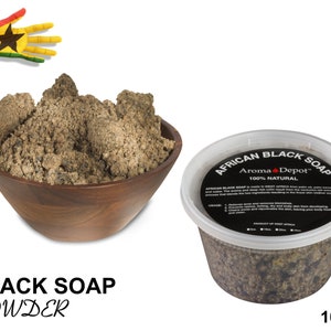 May include: A brown bowl filled with a large amount of dark brown African black soap powder. The powder is 100% natural and is made in West Africa. The label on the container reads "African Black Soap Aroma Depot™ 100% Natural".