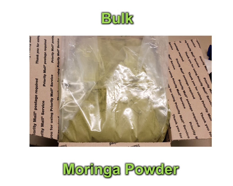 May include: A clear plastic bag filled with a large amount of green moringa powder. The bag is sitting inside a brown cardboard box with Priority Mail postage labels.