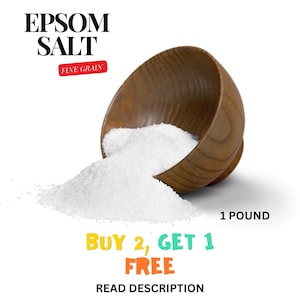 May include: A wooden bowl filled with white Epsom salt, spilling out onto a white background. The bowl is tilted to the side, and the salt is cascading out of it. The text "EPSOM SALT FINE GRAIN" is at the top of the image, and the text "1 POUND BUY 2, GET 1 FREE READ DESCRIPTION" is at the bottom of the image.