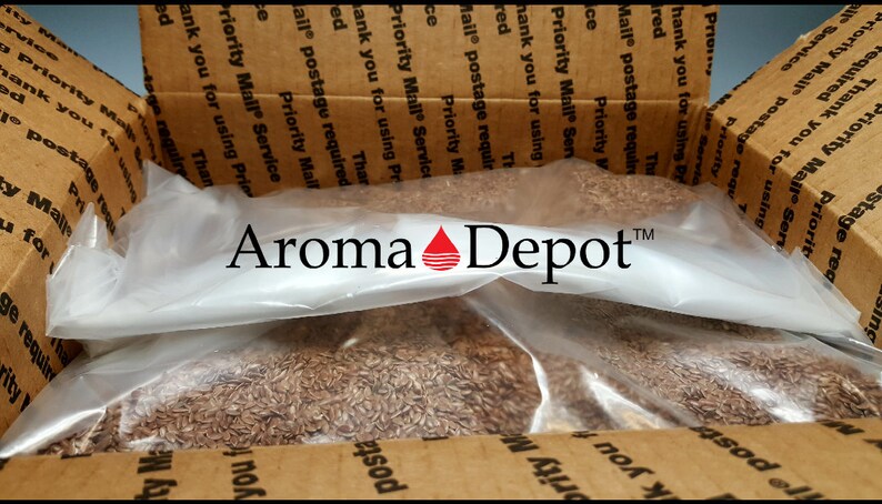May include: A brown cardboard box with the text "Priority Mail Service" printed on it. The box is open and contains a clear plastic bag filled with brown seeds. The bag has the text "Aroma Depot" printed on it.