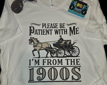 May include: White t-shirt with a black and white graphic of a horse-drawn carriage and the text "Please be patient with me I'm from the 1900s".
